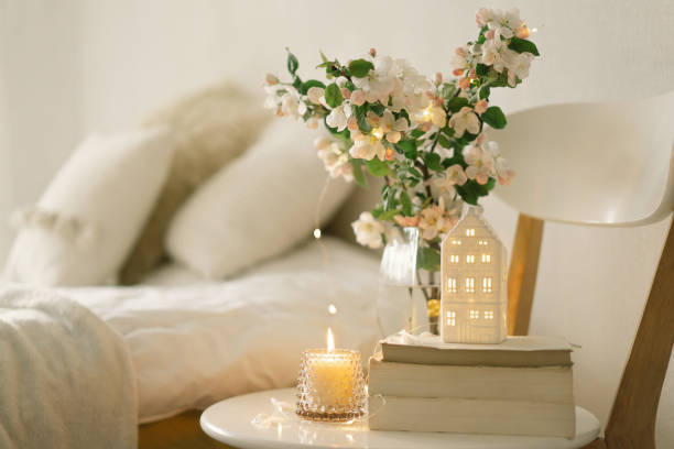 Book, candle and vase with apple spring flowers on table